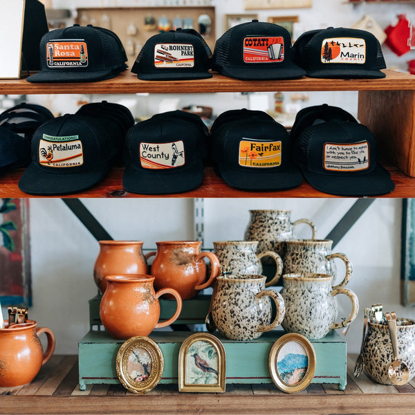 Faith Parker, founder of Boho Bungalow, arranging home decor on a shelf inside the Petaluma store.